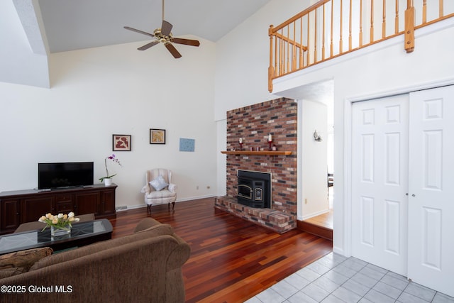 living room with light wood-style floors, baseboards, high vaulted ceiling, and a ceiling fan