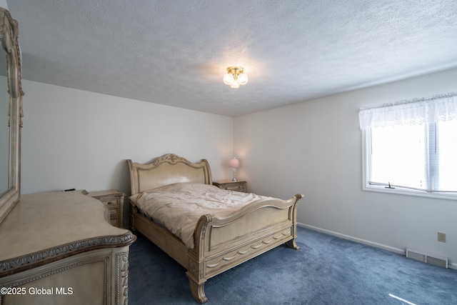 bedroom with a textured ceiling, dark colored carpet, visible vents, and baseboards