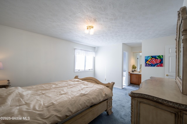 bedroom with light carpet, a textured ceiling, and ensuite bath