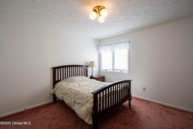 bedroom with baseboards, dark carpet, and a textured ceiling