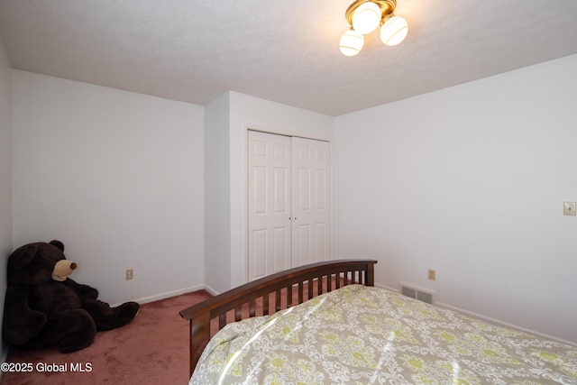 carpeted bedroom with a closet, visible vents, and baseboards