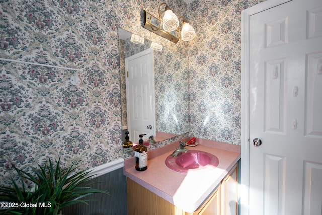 bathroom with wallpapered walls and vanity