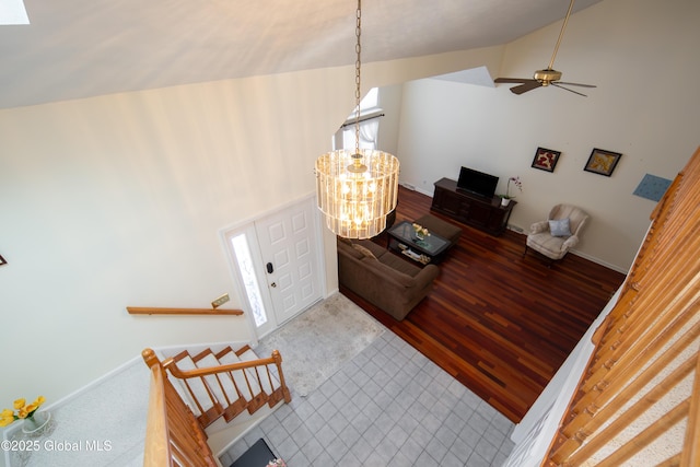 entryway featuring an inviting chandelier, baseboards, high vaulted ceiling, and wood finished floors