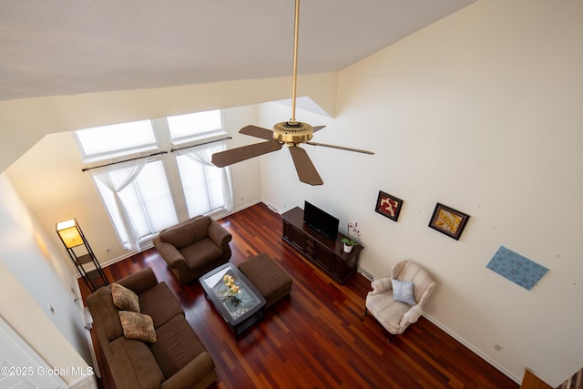 living room with dark wood-type flooring, vaulted ceiling, baseboards, and a ceiling fan