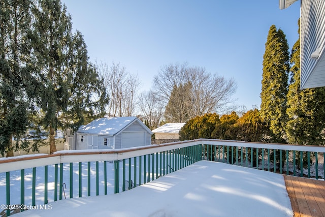 snow covered deck featuring an outbuilding