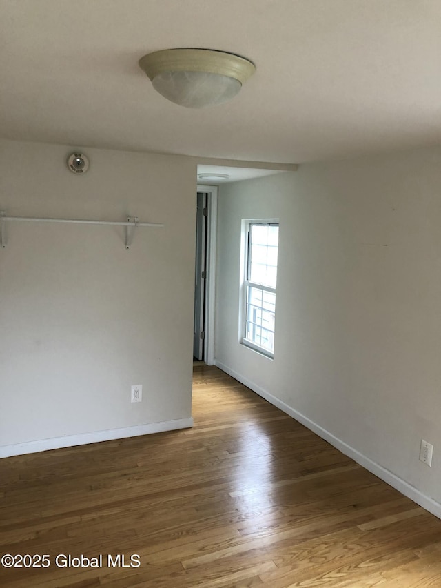 unfurnished room featuring baseboards and wood finished floors