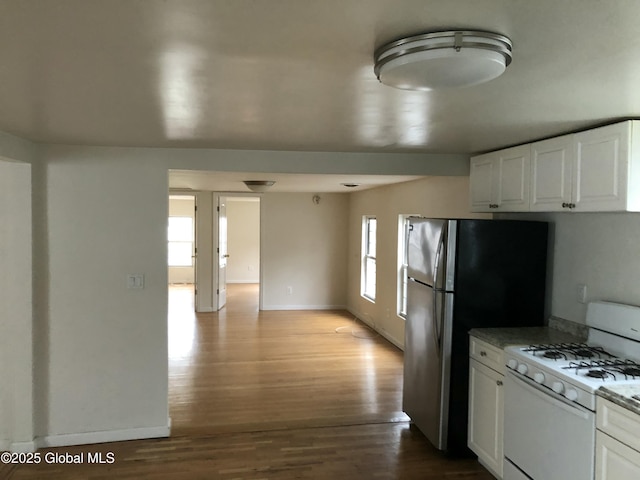 kitchen featuring baseboards, white cabinetry, white gas range, and wood finished floors