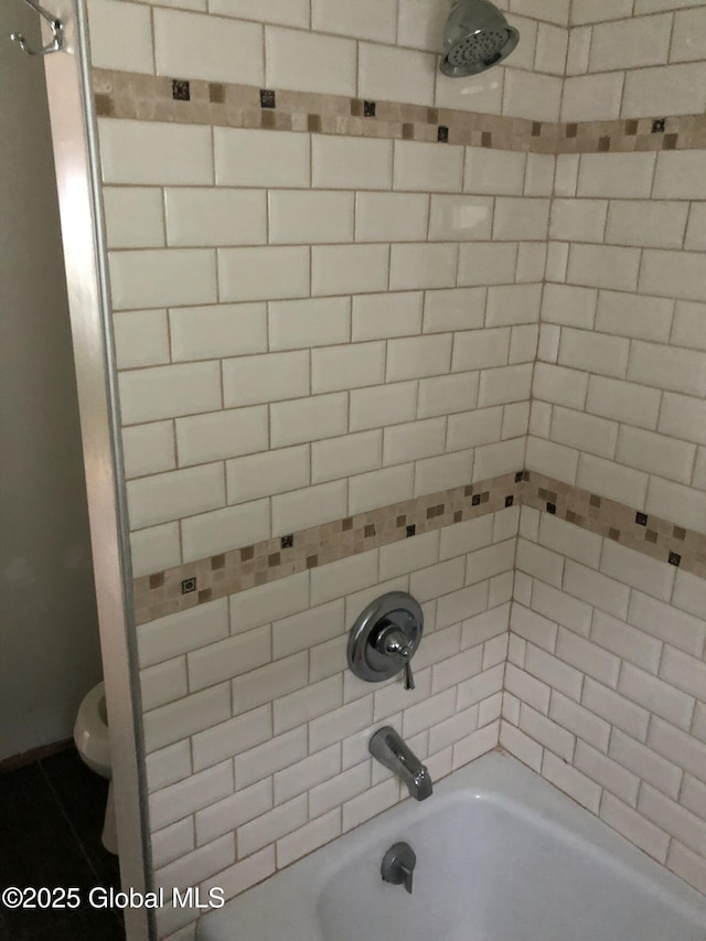 bathroom featuring bathtub / shower combination and toilet