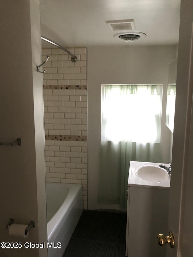 bathroom with tub / shower combination, visible vents, and vanity