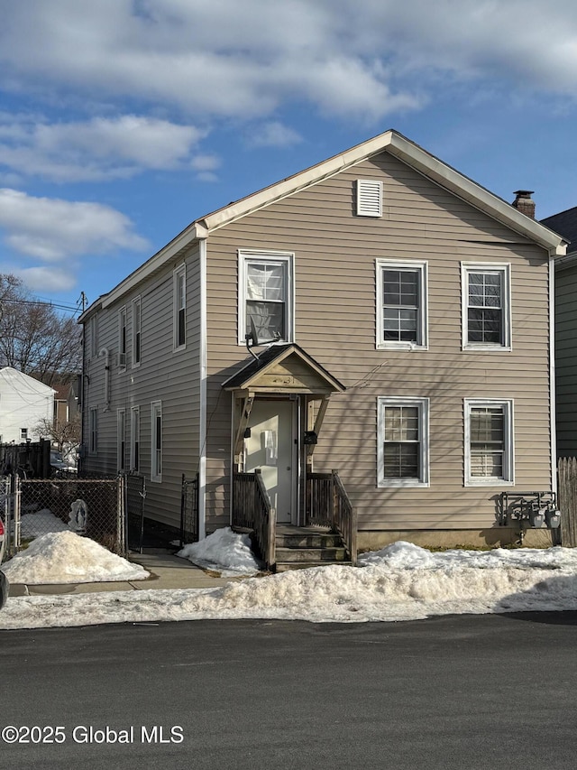 view of front of home featuring fence and a chimney