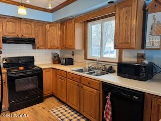 kitchen featuring black appliances, under cabinet range hood, light countertops, and a sink