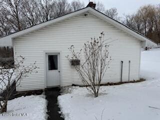 view of snow covered back of property