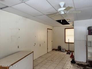 basement with ceiling fan and a drop ceiling