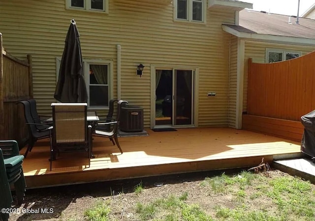 wooden terrace featuring central AC unit, fence, and outdoor dining space