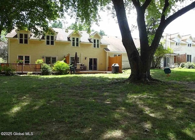 rear view of property with a yard and a deck