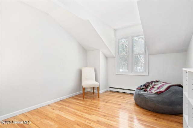 sitting room with a baseboard heating unit, lofted ceiling, baseboards, and wood finished floors