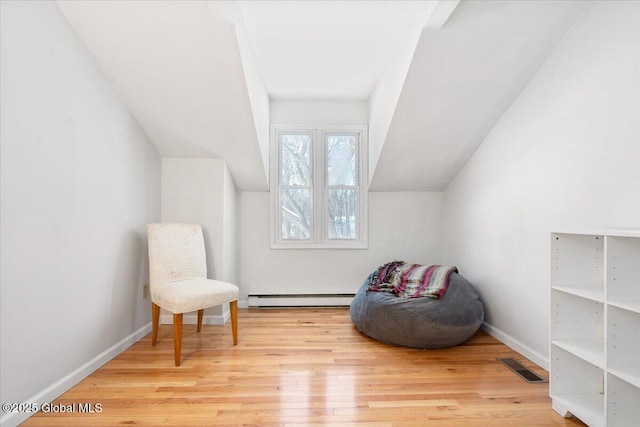 living area with a baseboard radiator, wood finished floors, visible vents, baseboards, and vaulted ceiling