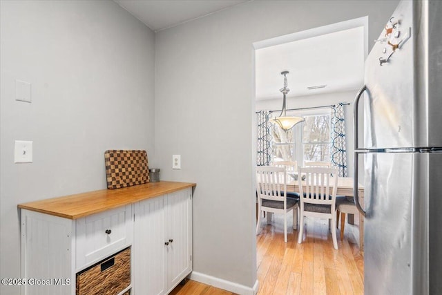 dining room with light wood-type flooring and baseboards