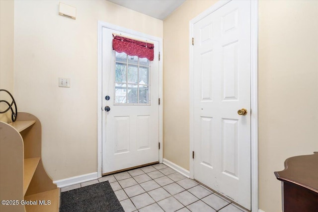 doorway with light tile patterned floors and baseboards