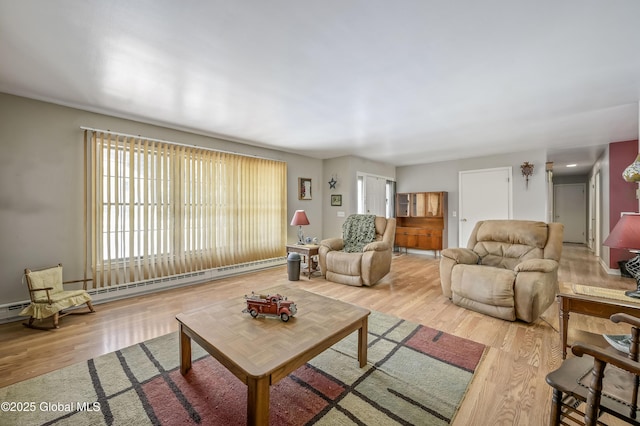 living room with baseboard heating, wood finished floors, and a wealth of natural light