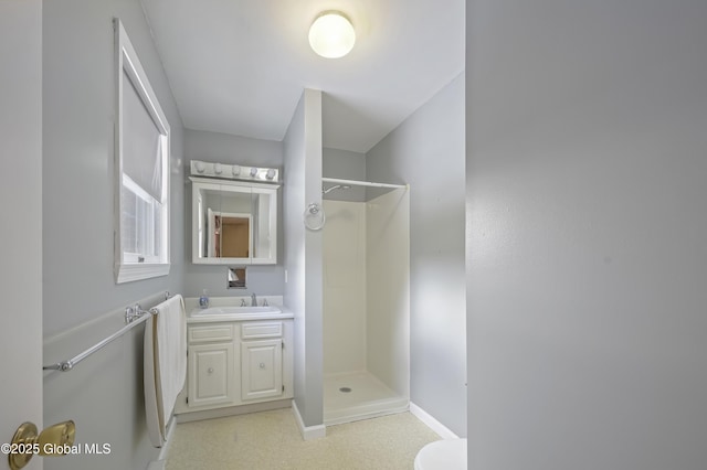 full bath featuring a stall shower, baseboards, and vanity