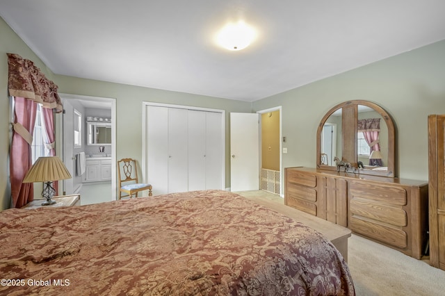 bedroom with carpet, a closet, a sink, and ensuite bathroom