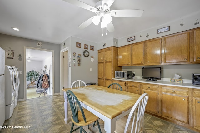 kitchen featuring separate washer and dryer, stainless steel microwave, tile patterned floors, and brown cabinets