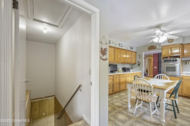 kitchen featuring ceiling fan, oven, visible vents, light countertops, and light floors