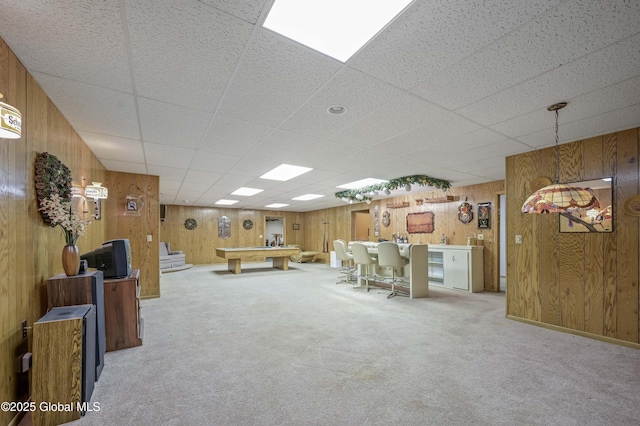 unfurnished living room featuring wood walls, billiards, stairs, and carpet flooring