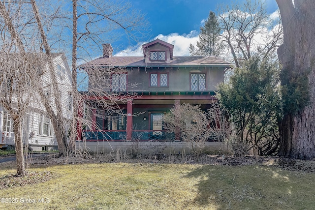 traditional style home featuring a front lawn and a chimney