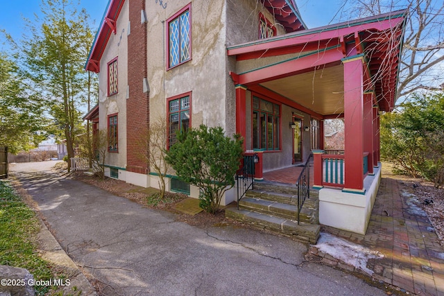 exterior space with a porch and stucco siding