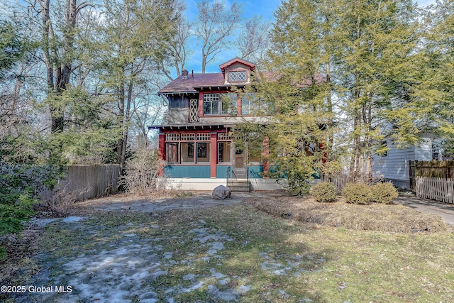 back of property with a sunroom and fence