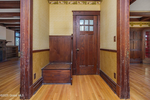 interior space featuring a wainscoted wall, wallpapered walls, and hardwood / wood-style flooring