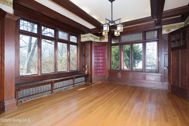 unfurnished room with beamed ceiling, a notable chandelier, and wood-type flooring