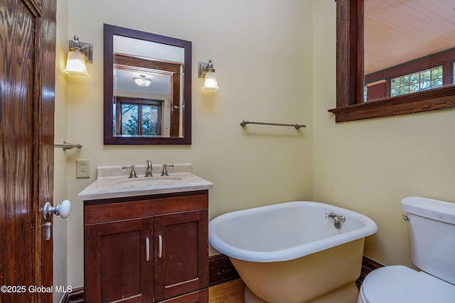 full bath featuring a freestanding bath, toilet, and vanity