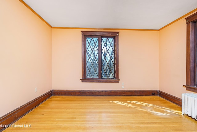 unfurnished room featuring radiator heating unit, wood finished floors, and ornamental molding