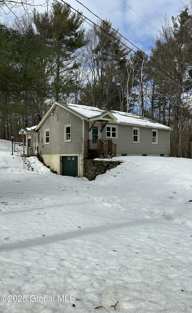 snow covered property with an attached garage