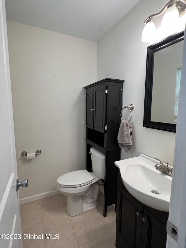 bathroom featuring toilet, vanity, baseboards, and tile patterned floors