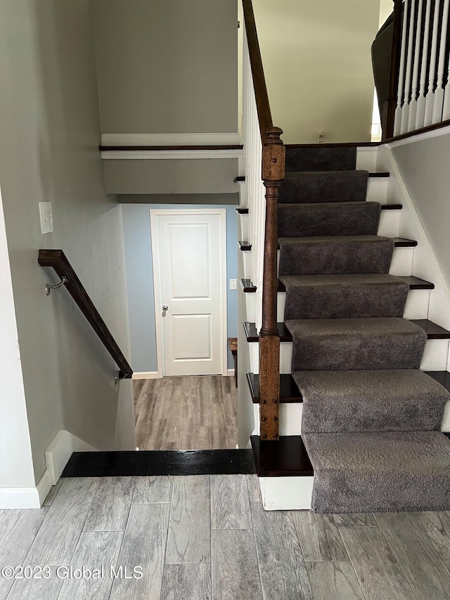 stairs featuring wood tiled floor and baseboards