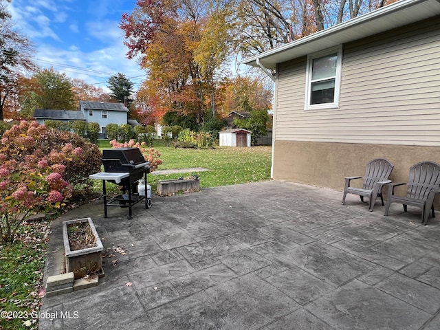 view of patio / terrace featuring a shed, grilling area, and an outbuilding