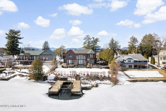 snow covered back of property featuring a residential view