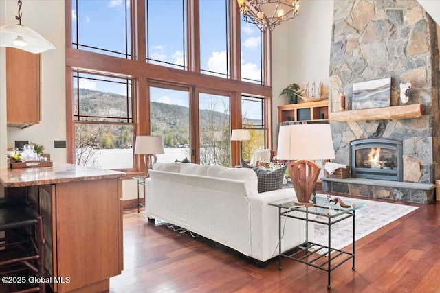 living room with a wealth of natural light, a mountain view, a fireplace, and dark wood-style flooring