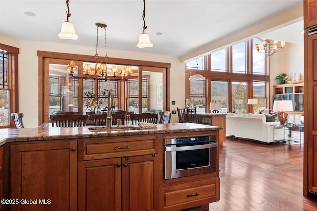 kitchen featuring a sink, an inviting chandelier, hanging light fixtures, and oven