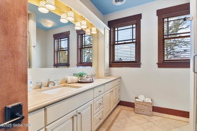 bathroom featuring a sink, baseboards, and a wealth of natural light