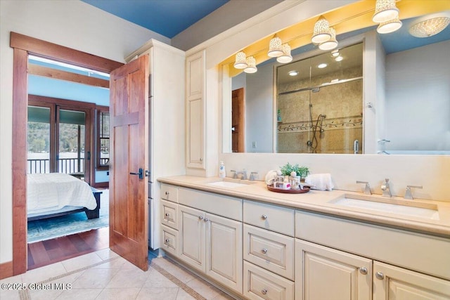 bathroom with double vanity, a stall shower, ensuite bathroom, and a sink