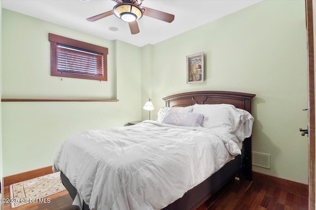 bedroom with ceiling fan, visible vents, baseboards, and wood finished floors