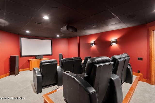 cinema featuring a paneled ceiling, light colored carpet, visible vents, and baseboards