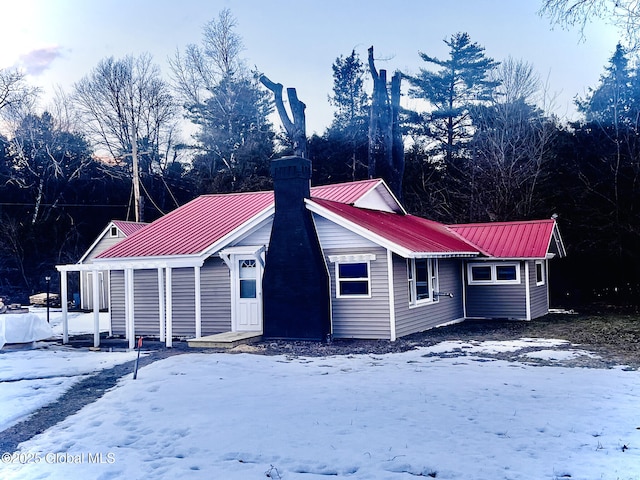 exterior space featuring metal roof and a chimney