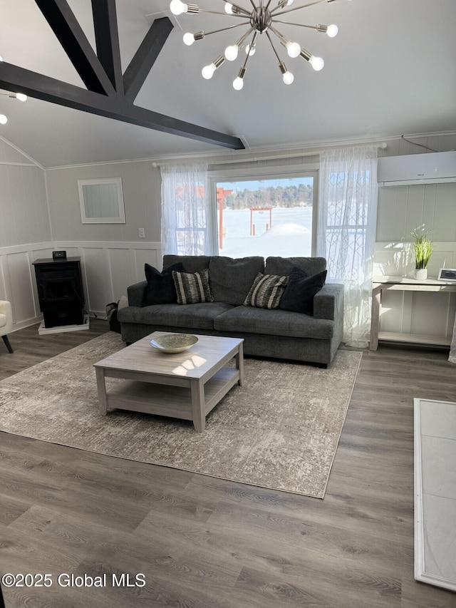 living area with wood finished floors, vaulted ceiling with beams, a decorative wall, a notable chandelier, and a wall mounted AC