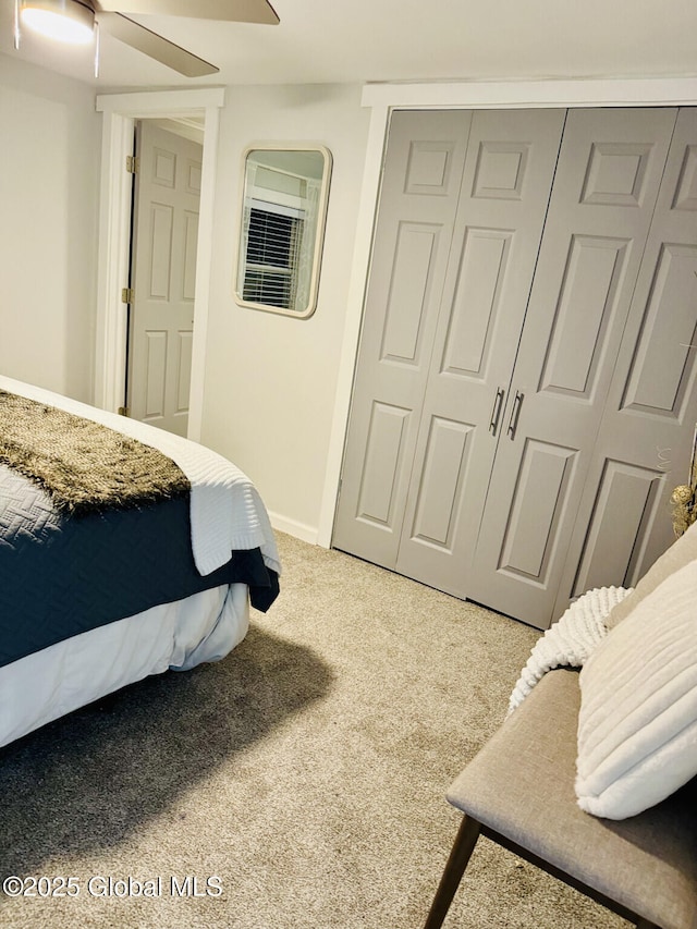 bedroom featuring light carpet, baseboards, a ceiling fan, and a closet